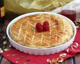 Une délicieuse galette pistache framboise dorée, décorée de fruits rouges frais, prête à être dégustée.