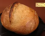 Belle miche de pain artisanal, prête après son temps de repos maximum. La croûte dorée et craquelée promet un délice.