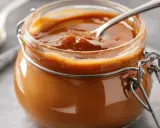 Un pot de caramel beurre salé avec une cuillère. Ce délice onctueux, fait avec du beurre doux, invite à la gourmandise.