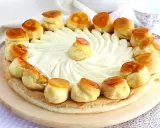 Un magnifique gâteau Saint-Honoré, orné de choux caramélisés et d'une crème onctueuse, prêt à être dégusté.