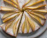 Gâteau au yaourt recette illustrée : un délicieux gâteau aux poires, saupoudré de sucre glace, prêt à être dégusté.