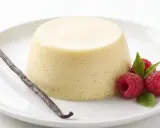 Bavaroise vanille on a white plate, garnished with raspberries, mint leaves and a vanilla bean.