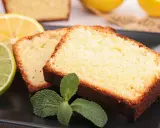 Tranches de cake au citron facile, garnies de menthe fraîche, avec des citrons et citrons verts en arrière-plan.