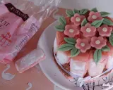 Charlotte aux biscuits roses de Reims, décorée de fleurs en pâte d'amande. Un biscuit rose saupoudré de sucre est à côté.