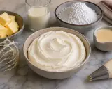 Préparation d'une crème au beurre traditionnelle : beurre, sucre glace, lait, et une poche à douille prête à l'emploi.