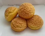 Quatre choux craquelin dorés et croustillants, prêts à être garnir.