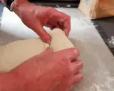Mains travaillant la pâte à pain, étape d'autolyse. La pâte est souple et prête à être façonnée.