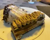 Deux parts de gâteau, dont une avec une crème légère et des copeaux de chocolat, l'autre un opéra conticini, sur une assiette blanche.