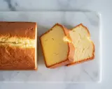 Un quatre-quarts à l'ancienne, moelleux et doré, coupé en tranches sur une planche de marbre.