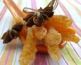 Oranges confites, une recette italienne gourmande, présentées sur une cuillère avec des étoiles de badiane.