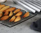Biscuits dorés en forme de dent de loup refroidissent sur une grille.