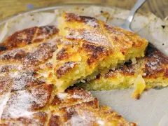Un kouign amann doré et croustillant, saupoudré de sucre glace, prêt à être dégusté.