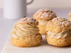 Trois choux pâtisseries garnis d'une crème onctueuse à la vanille, saupoudrés de sucre glace.