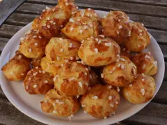 Assiette de chouquettes traditionnelles dorées, parsemées de sucre perlé, prêtes à être dégustées.