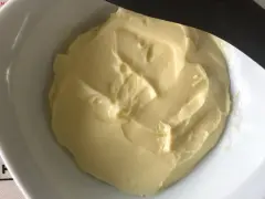 Beurre crémeux dans un bol blanc, prêt à être incorporé dans une pâte feuilletée.