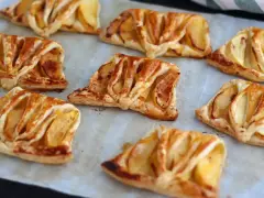 Plusieurs chaussons aux pommes dorés et feuilletés, prêts à être dégustés.