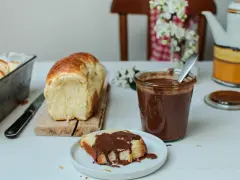 Une tranche de brioche moelleuse, nappée de chocolat, prête à être dégustée. Une invitation à réaliser cette recette brioche maison.