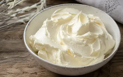 Un bol rempli de crème au beurre professionnelle, onctueuse et aérienne, prête à être utilisée pour des décorations pâtissières.