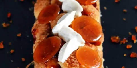 Bûche Saint Honoré gourmande, garnie de choux craquelins, crème onctueuse et éclats de caramel ambré. Un délice visuel et gustatif.