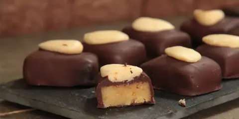 Délicieux bonbons au chocolat noir, garnis d'une pâte d'amande et surmontés d'une amande entière. Une recette gourmande à essayer !