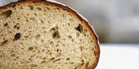 Tranche de pain artisanal à la mie aérée et à la croûte dorée. Pour savoir comment conserver le pain, il faut le garder à température ambiante.