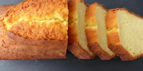 Un quatre-quarts breton, doré et moelleux, coupé en tranches sur fond sombre. Parfait pour une recette simple et gourmande.