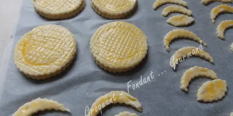 Sur une plaque, des disques de pâte feuilletée prêts à cuire, certains en forme de croissant, pour une délicieuse croute vol au vent.