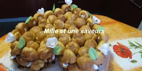 Magnifique chou pièce montée, un délice pour les yeux et les papilles, ornée de fleurs blanches et de feuilles vertes.
