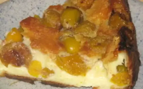 Une part de flan aux mirabelles, avec sa croûte dorée et sa garniture crémeuse aux fruits jaunes.