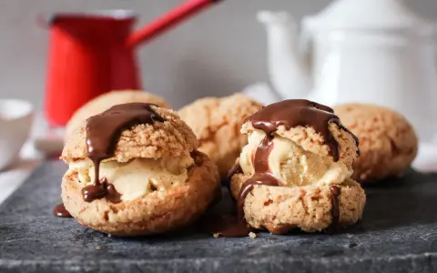 Délicieux profiteroles chocolat, garnis de glace et nappés de sauce au chocolat, prêts à être dégustés.
