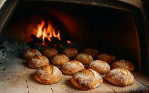 Des pains dorés attendent leur temps de cuisson du pain au four, avec des flammes vives en arrière-plan.