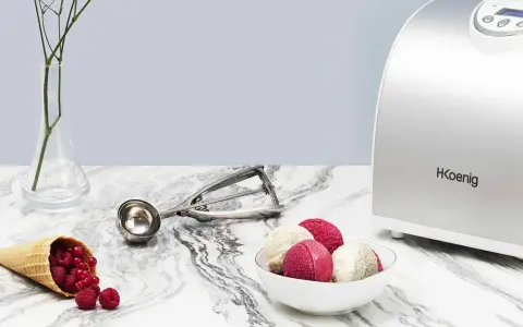 La turbine à glace Koenig HF340 prépare de délicieuses glaces maison. Une cuillère à glace et des fruits rouges complètent la scène.