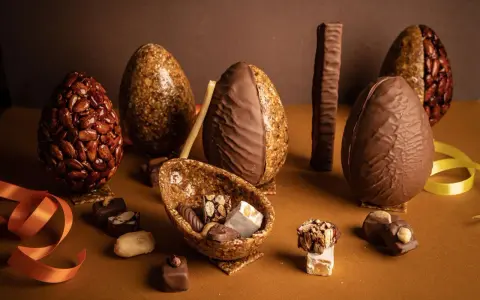 Œufs en chocolat et nougatine, certains décorés d'amandes croquantes. Une composition gourmande pour Pâques.