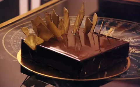 Gâteau royal chocolat Michalak, un délice glacé aux éclats dorés, prêt à être dégusté.