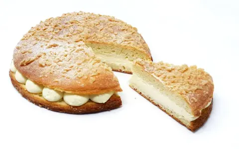 La tropézienne, le meilleur pâtissier, est une brioche garnie de crème onctueuse, saupoudrée de sucre glace et de crumble croustillant.
