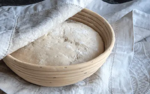 Pâte à pain dans un banneton, prête à lever. Trop de levure dans le pain peut entraîner des conséquences indésirables sur la texture et le goût.