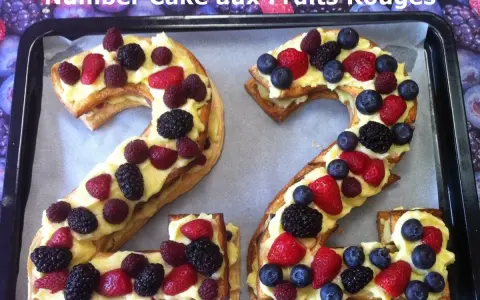 Un délicieux number cake aux fruits rouges, formant les chiffres 2 et 4, garni de crème pâtissière et de baies fraîches.