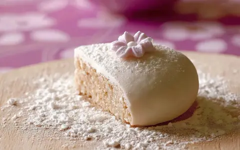 Gâteau recouvert de pâte à sucre, saupoudré de sucre glace. Une petite fleur en pâte à sucre décore le dessus. Parfait pour une recette de pâte à sucre.