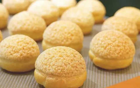 Une rangée de craquelins choux dorés et croustillants, prêts à être dégustés.