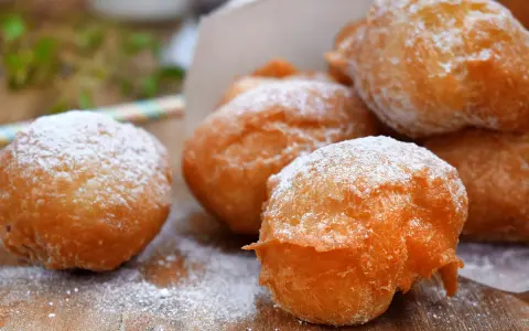 Des pets de none dorés et saupoudrés de sucre glace, prêts à être dégustés. Un délice croustillant et moelleux.