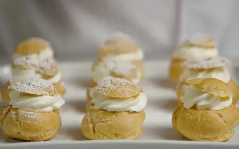 Petits choux garnis de crème fouettée, saupoudrés de sucre glace. La cuisson des choux est parfaite, dorée et légère.