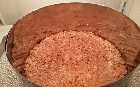 Fond de gâteau croustillant sans cuisson, une texture gourmande de chocolat et de riz soufflé dans un cercle à pâtisserie.
