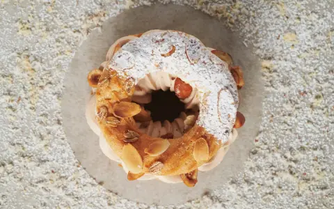 Un Paris-Brest aérien, garni d'une crème onctueuse et décoré d'amandes effilées. Le praliné pour Paris-Brest est ici sublimé.