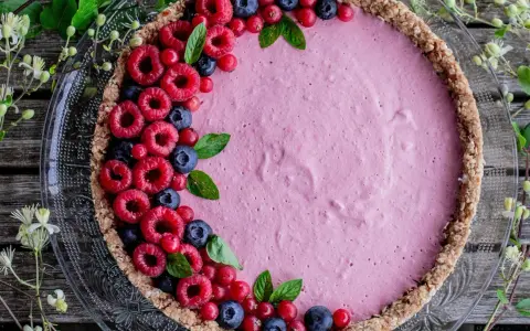 Délicieuse tarte aux fruits avec une garniture rose et des framboises, myrtilles et groseilles. La décoration tarte aux fruits est simple et élégante.