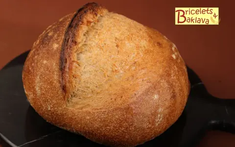 Belle miche de pain artisanal, prête après son temps de repos maximum. La croûte dorée et craquelée promet un délice.