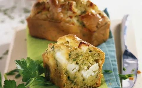 Un délicieux cake de Sophie aux courgettes et feta, garni de morceaux généreux de fromage.