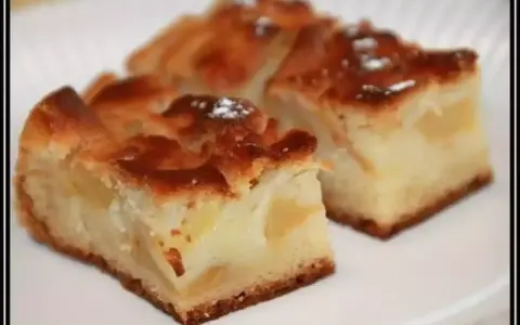 Trois parts de gâteau moelleux sans oeuf aux pommes, saupoudrées de sucre glace, sur une assiette blanche.
