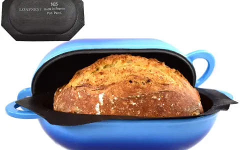 Pain doré dans une cocotte bleue, prêt pour la cuisson. Le couvercle noir avec "LOAFNEST" suggère une cuisson parfaite, chaleur tournante ou pas.