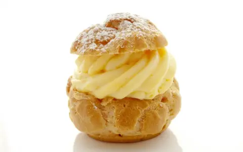 Un déliceux chou à la crème, saupoudré de sucre glace, avec une généreuse garniture de crème pâtissière onctueuse.
