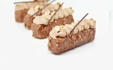 Délicieux entremets chocolat praliné, recouverts de noisettes croquantes et surmontés d'une crème onctueuse.